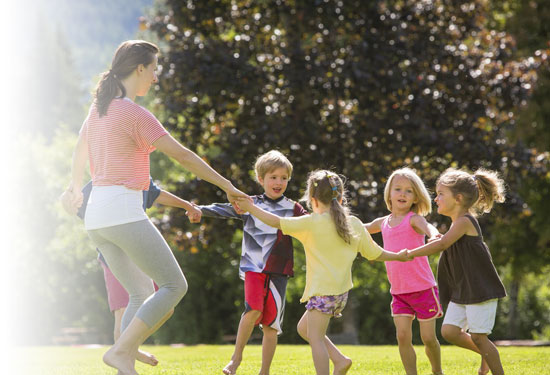 Photo of teacher with students playing outdoors